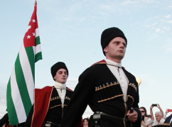 A horse column with the national flag of Abkhazia passed along the Quay of the Makhadzhirs. Riders passed the flag to the chief of the Guard of Honor Company.