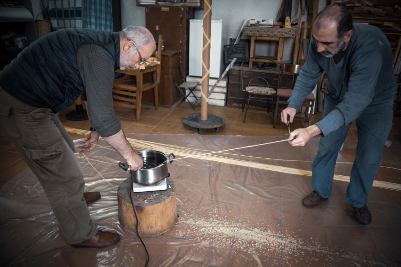 Sanatçı Batal Capua ve demirci Timur Dzidzaria, geleneksel Abhaz mumu aşeamakayı hazırıyor.